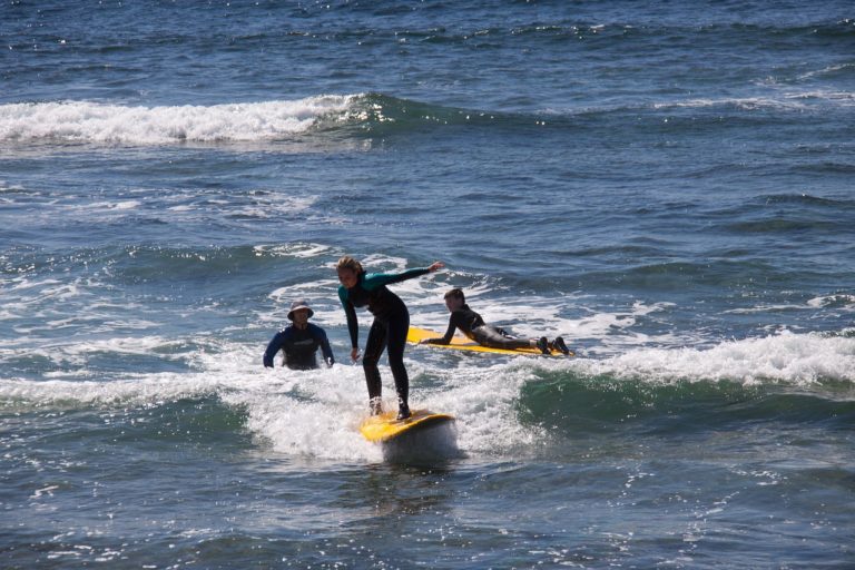 beginner surfer surfing a small wave on a foam board